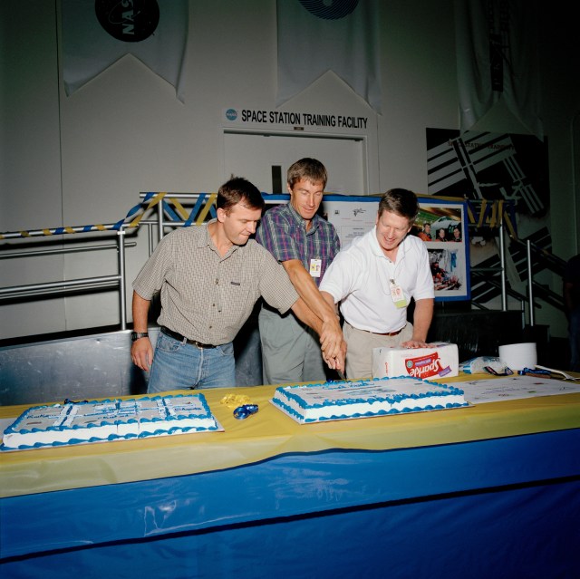 Symbolizing the completion of its preflight training in the United States, the Expedition One crew is treated to a celebratory cake from the training team in the Mission Simulation and Training Facility at the Johnson Space Center (JSC). The international crew, from the left, Russian cosmonauts Yuri P. Gidzenko and Sergei K. Krikalev, along with U.S. astronaut William M. Shepherd, departed August 10 for Star City, Russia, where they will continue to train until their scheduled October 30 launch aboard a Russian Soyuz rocket. They will be the first long-duration residents of the station.