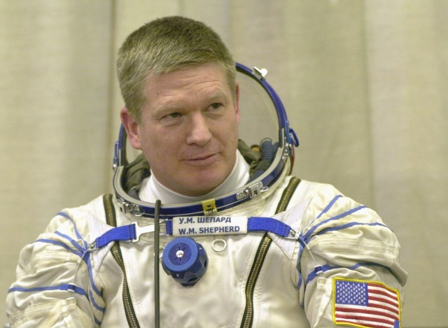 Expedition 1 commander William M. (Bill) Shepherd, wearing a Sokol suit, awaits a seat check for the Soyuz spacecraft at Baikonur. Out of frame are Soyuz pilot Yuri P. Gidzenko and flight engineer Sergei K. Krikalev.