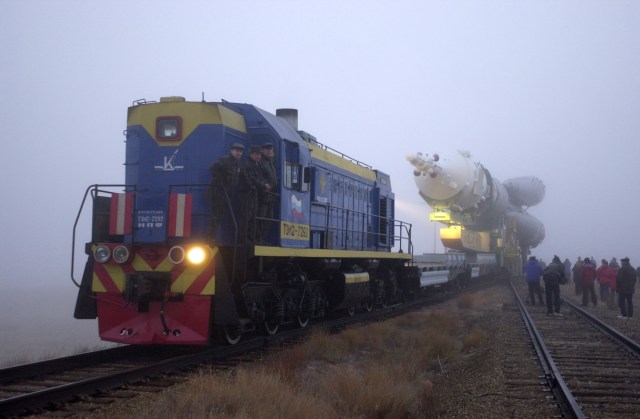A train engine transports the Soyuz rocket from the assembly building toward the launch pad at the Baikonur complex in Kazakhstan.