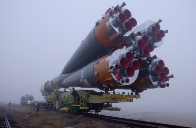 An aft view of the Soyuz rocket affords an excellent look at the rocket's engine area as a train transports it from the assembly building toward the launch pad at the Baikonur complex in Kazakhstan.