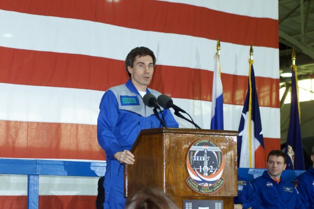 Cosmonaut Sergei K. Krikalev, Expedition One flight engineer, speaks to a crowd of greeters during a crew return ceremony in Ellington Field's Hangar 990. Pictured in the background on the dais is cosmonaut Yuri P. Gidzenko, Soyuz commander for the Expedition One crew.
