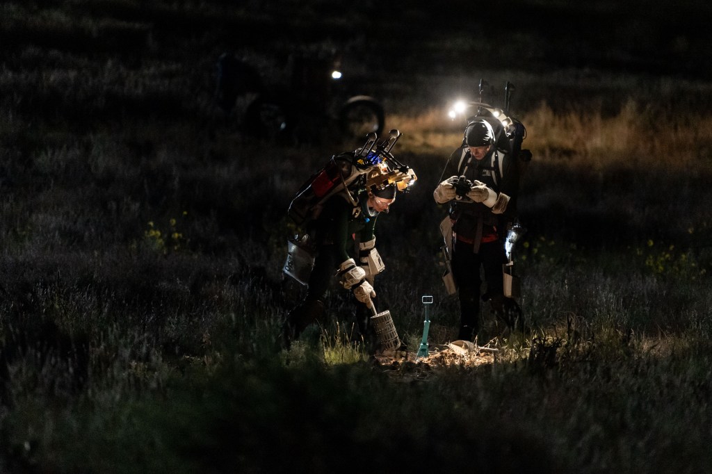 NASA astronauts Zena Cardman (left) and Drew Feustel (right) use geology tools during a simulated moonwalk in the Arizona desert.