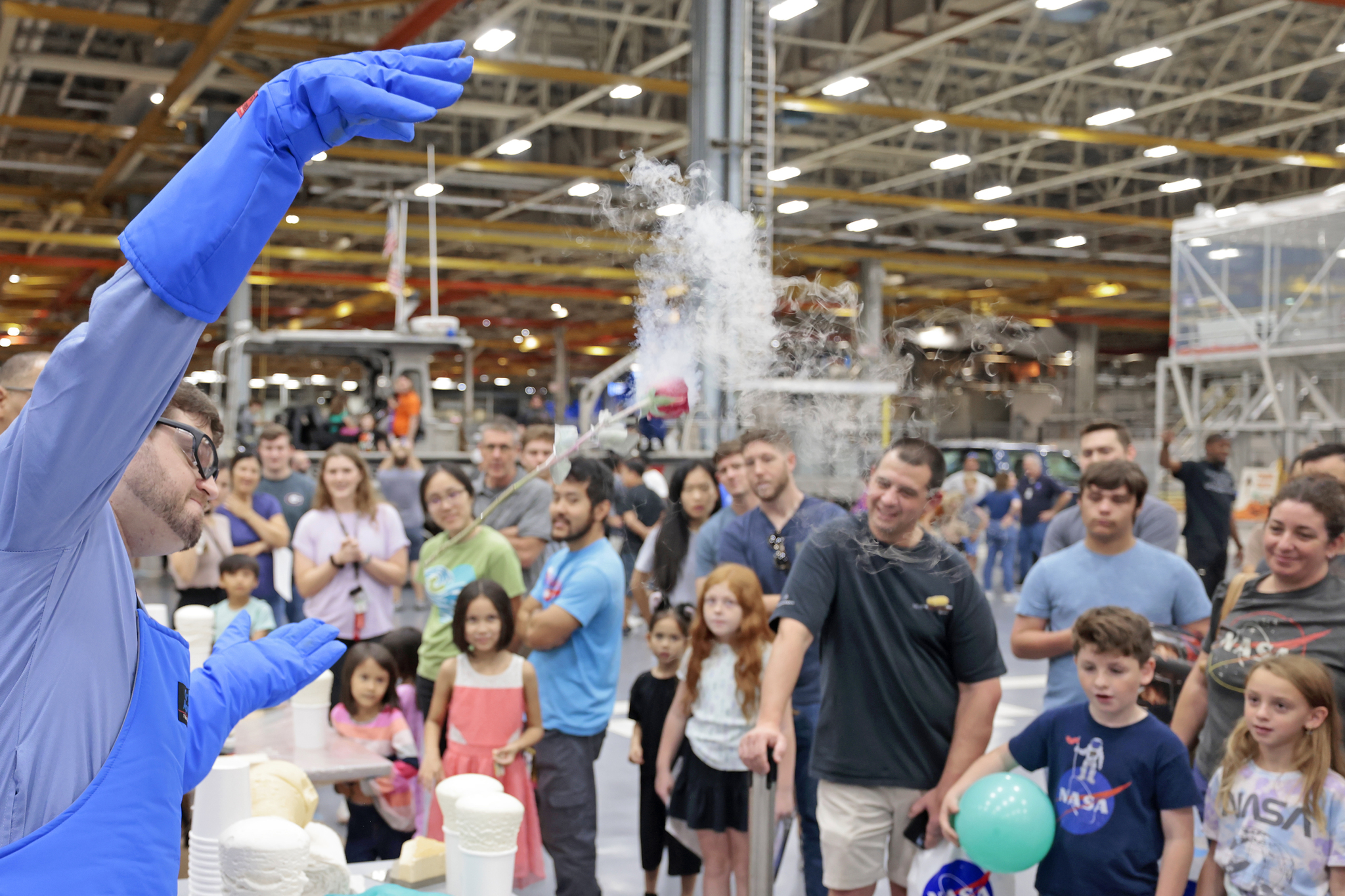 Attendees observe a liquid nitrogen demonstration at the Boeing table at Michoud Family Day.