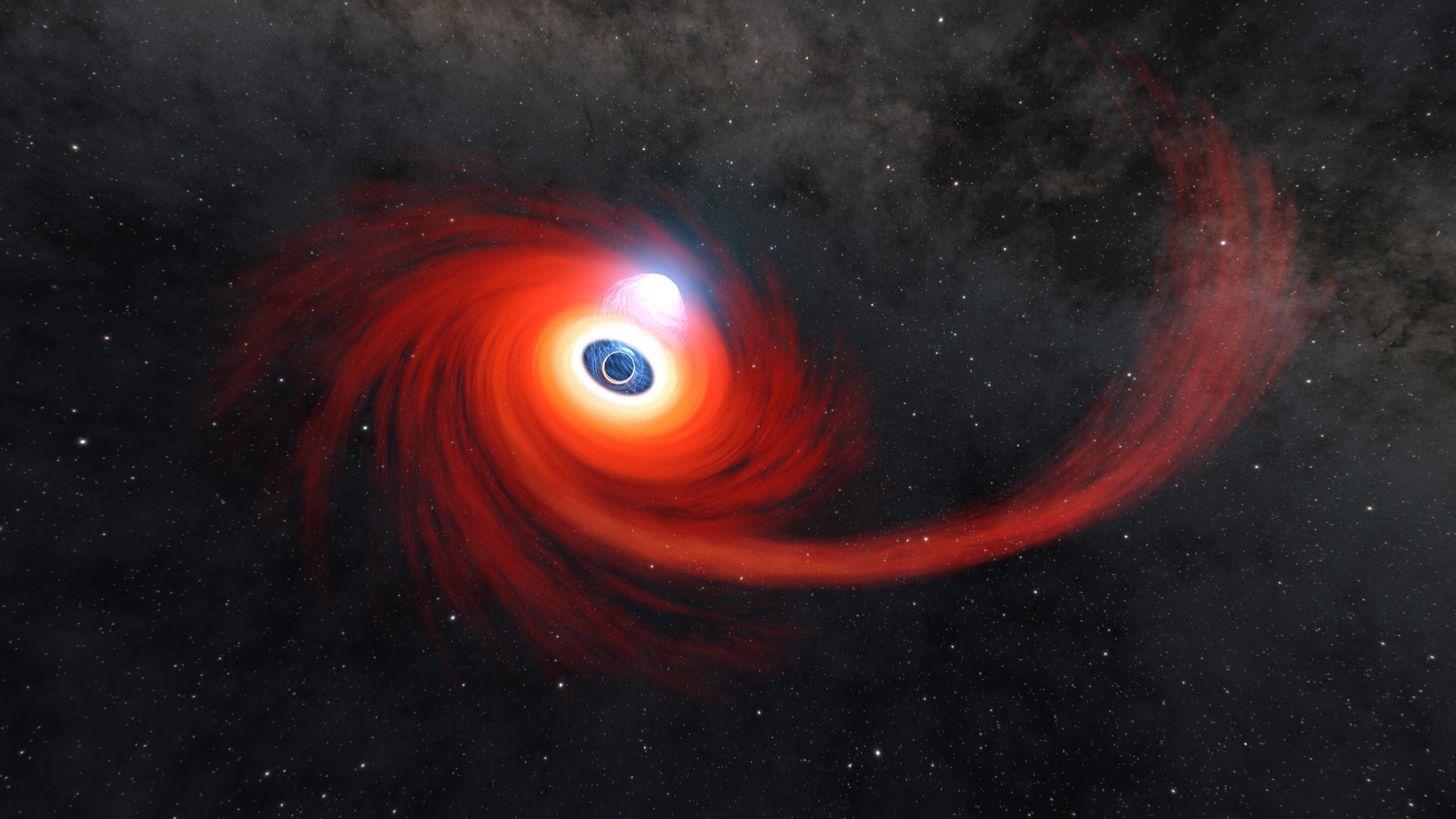 Against a black background dotted with stars, a disk of hot red gas swirls around a black hole in this illustration. There is a long stream of hot gas extending out to the right, which is feeding into the disk, and a bright cloud of plasma hovering just above the center of the black hole.