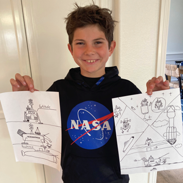Nine-year-old boy, Luca Pollack, holds up to pages of illustrations he made of his image including launch, orbit, landing, and exploring at the destination of his mission concept.