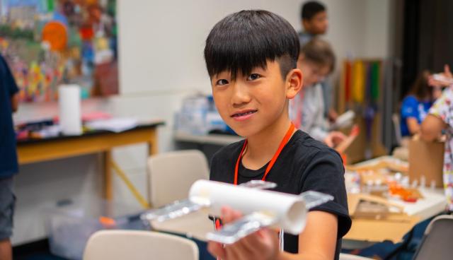 A camp participant shows his handmade satellite