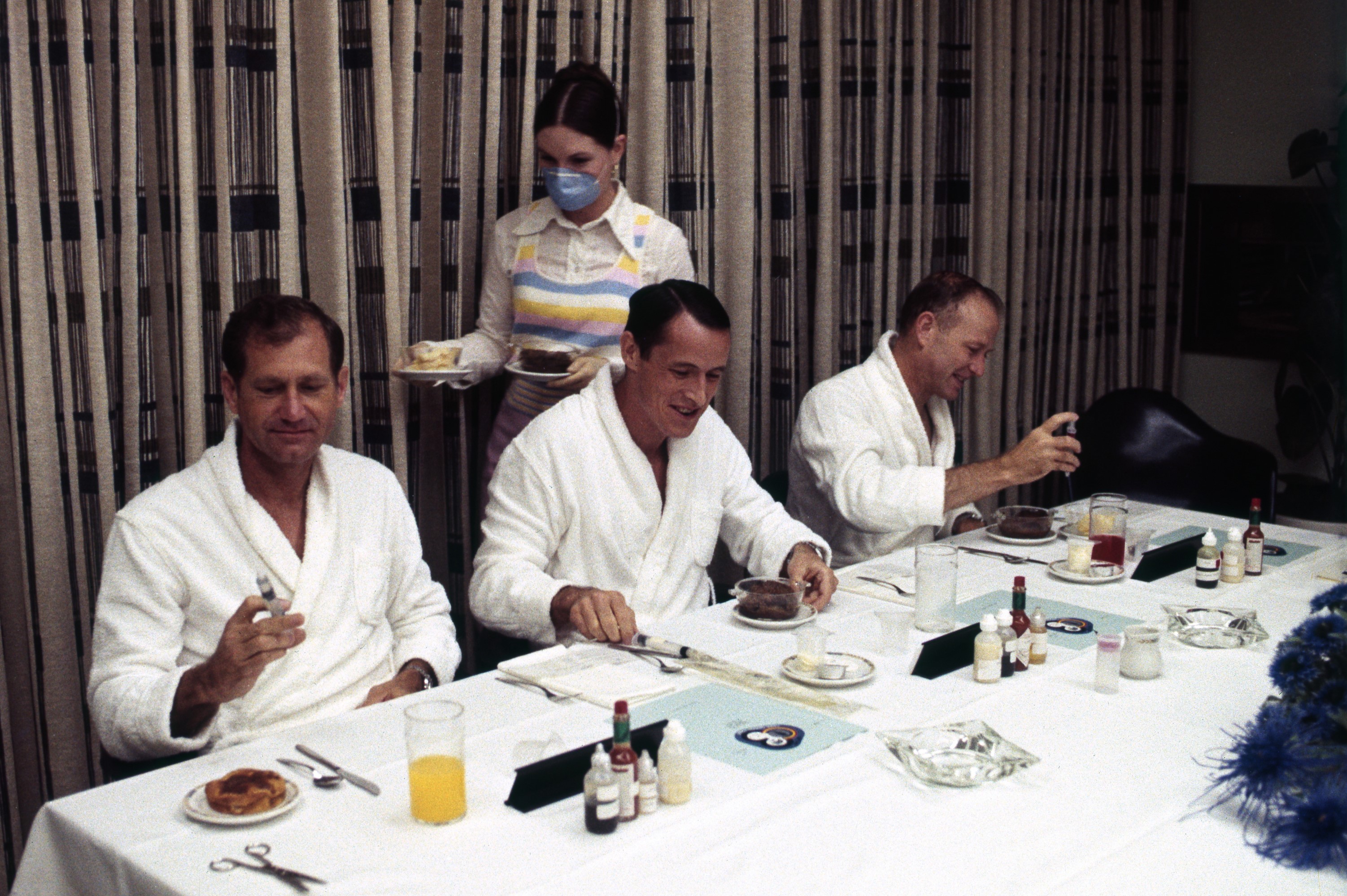 Photo of Skylab 4 astronauts William R. Pogue, left, Edward G. Gibson, and Gerald P. Carr enjoy the traditional prelaunch breakfast