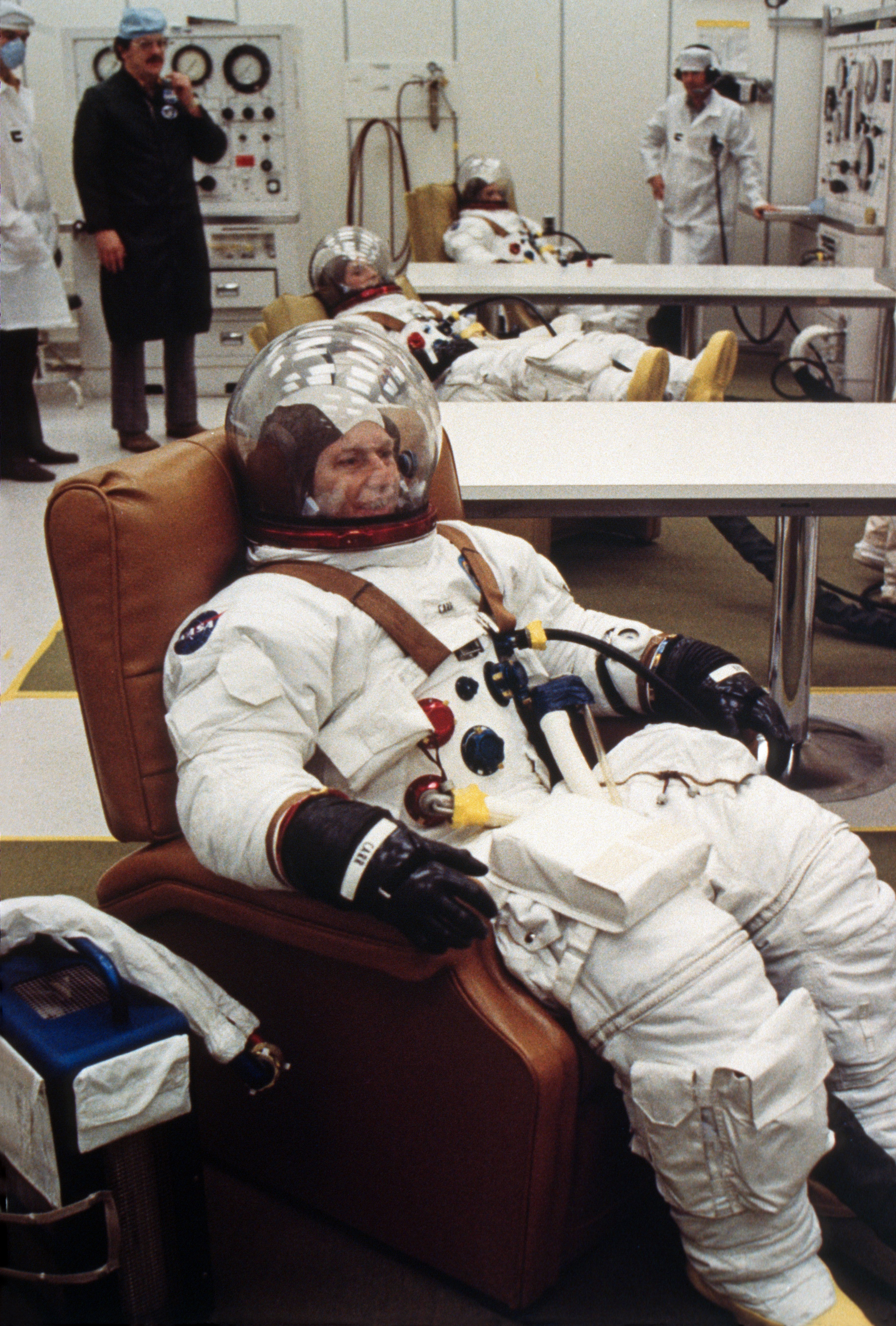 Carr, Gibson, and Pogue test the pressure integrity of their spacesuits before launch