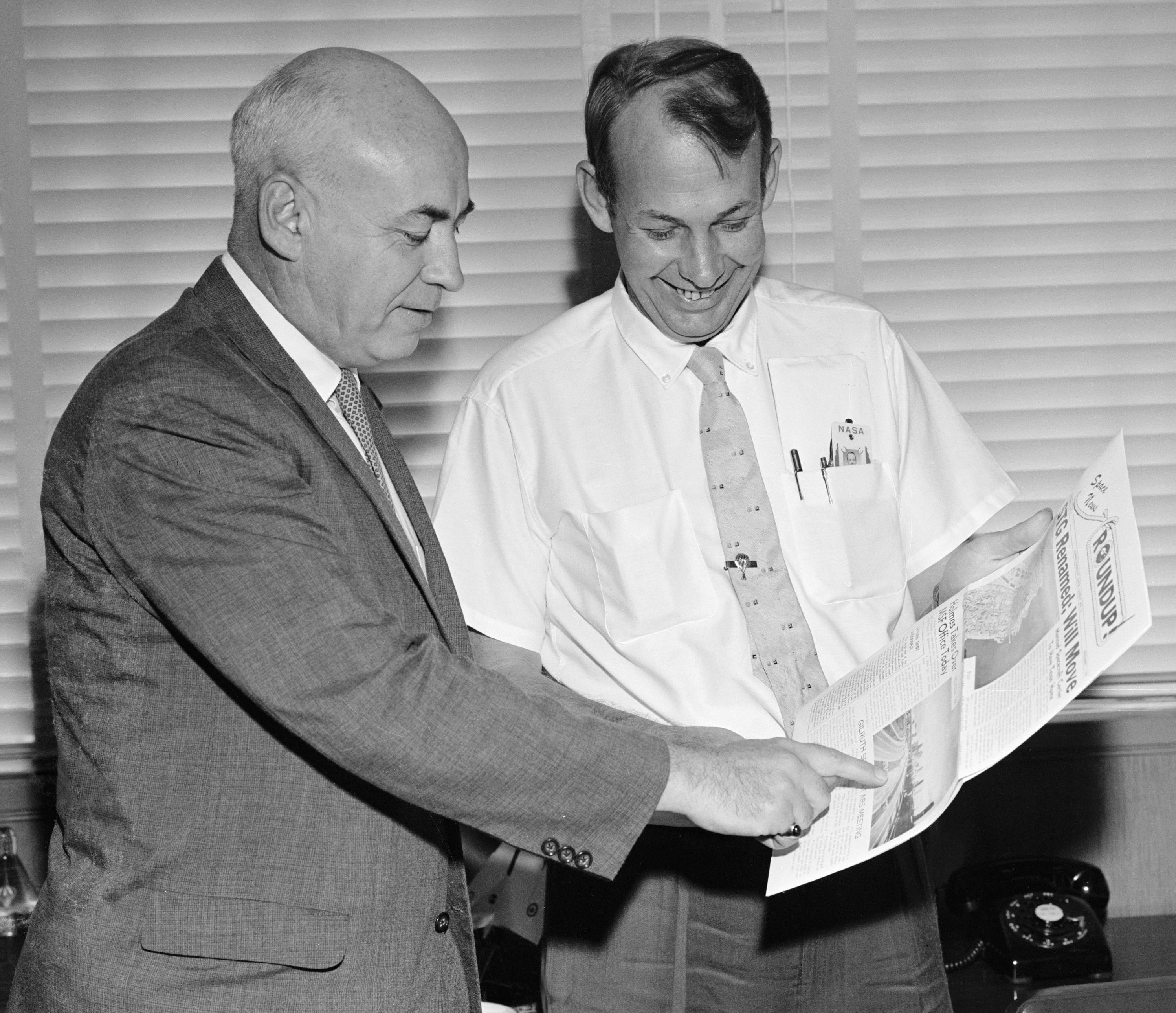 Space Task Group (STG) Director Robert R. Gilruth, left, and his special assistant Paul E. Purser hold the Nov. 1, 1961, edition of the Space News Roundup employee newsletter announcing the move of the STG to Houston and its renaming as the Manned Spacecraft Center (MSC), now NASA’s Johnson Space Center