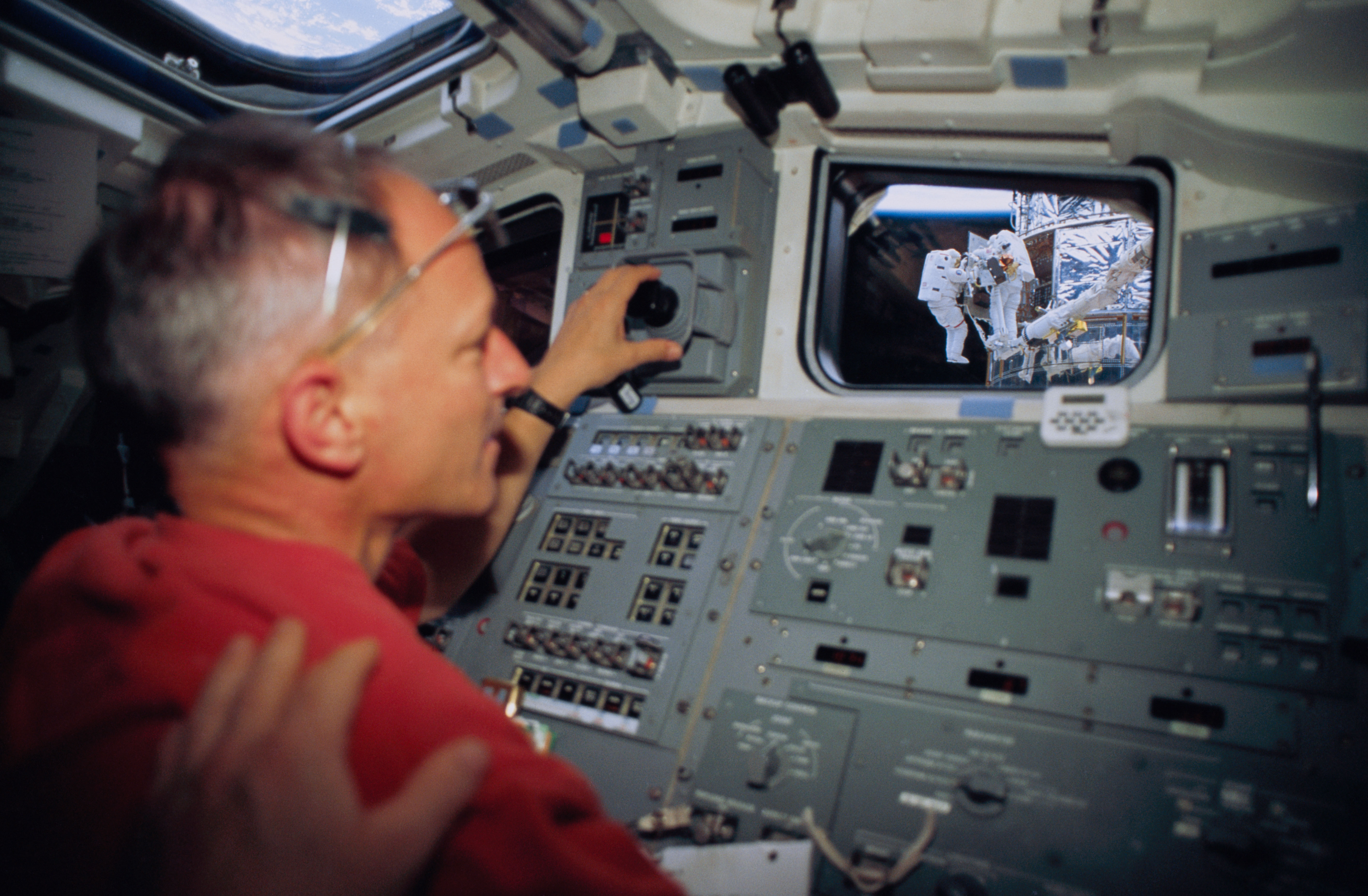 European Space Agency astronaut Claude Nicollier operates the shuttle’s Remote Manipulator System (RMS) or robotic arm in support of the spacewalks