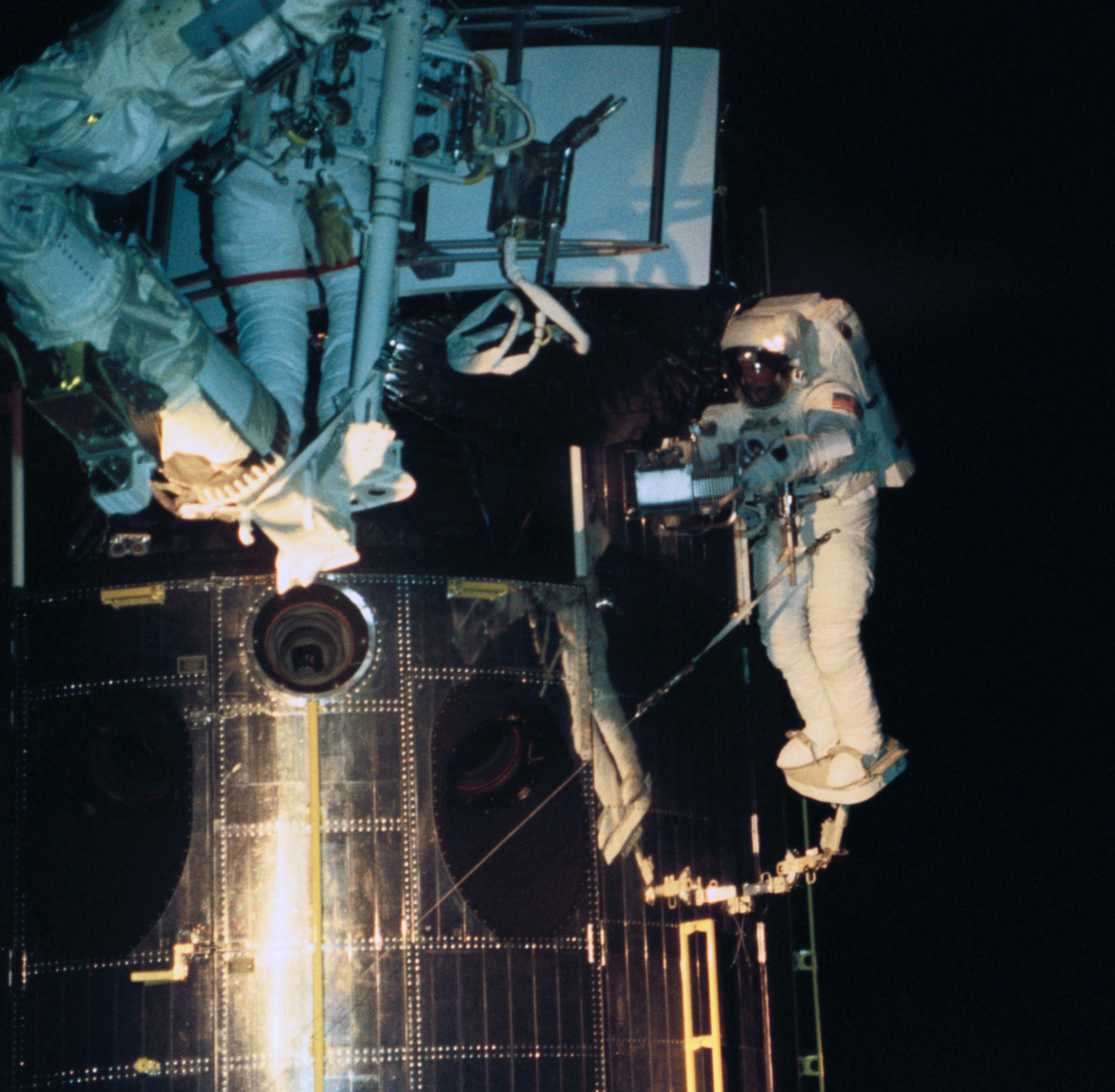 With European Space Agency astronaut Claude Nicollier operating the Remote Manipulator System from inside the shuttle, Hoffman guides the new WFPC2 into position, with Musgrave ready to assist