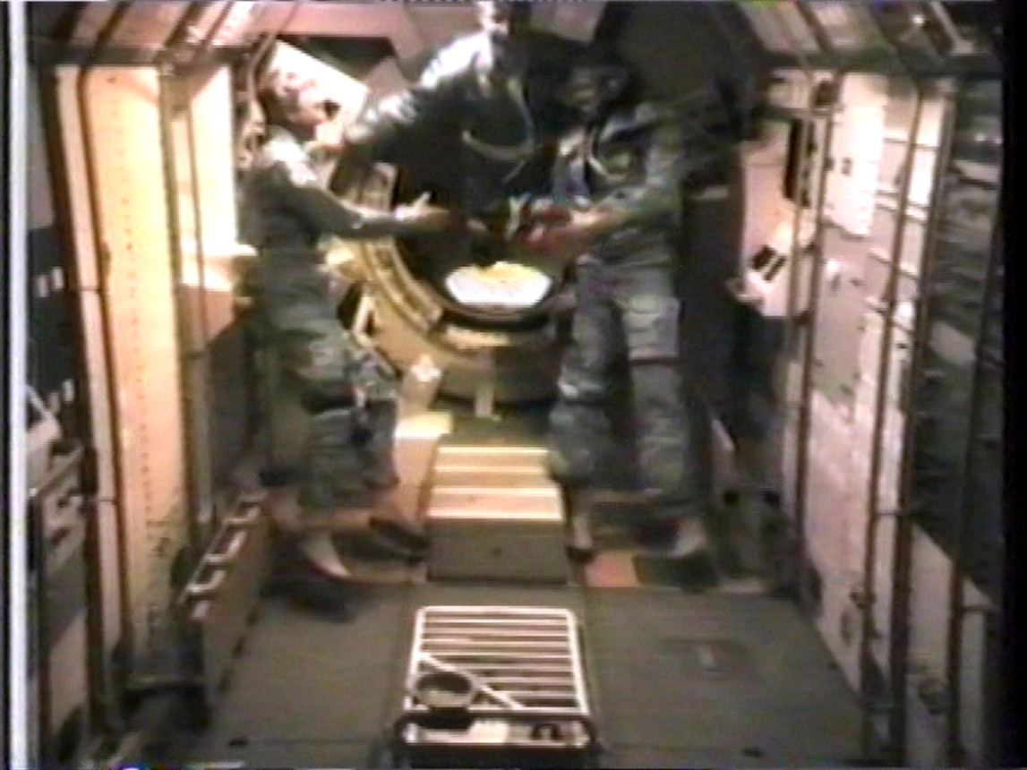 Owen K. Garriott, left, Ulf Merbold, and Byron K. Lichtenberg enter the Spacelab for the first time to begin activating the module