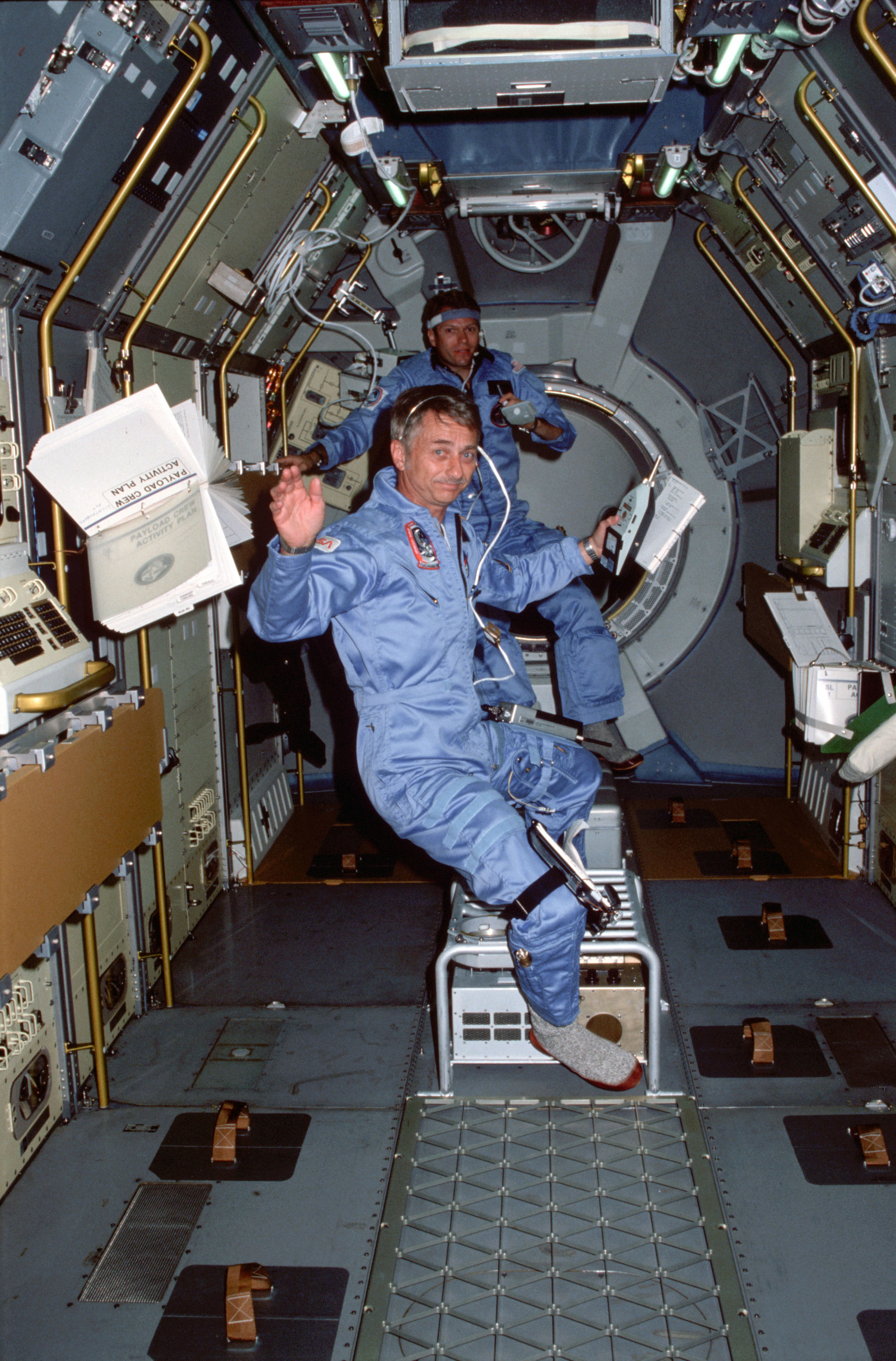 Garriott, front, and Lichtenberg at work in the Spacelab module