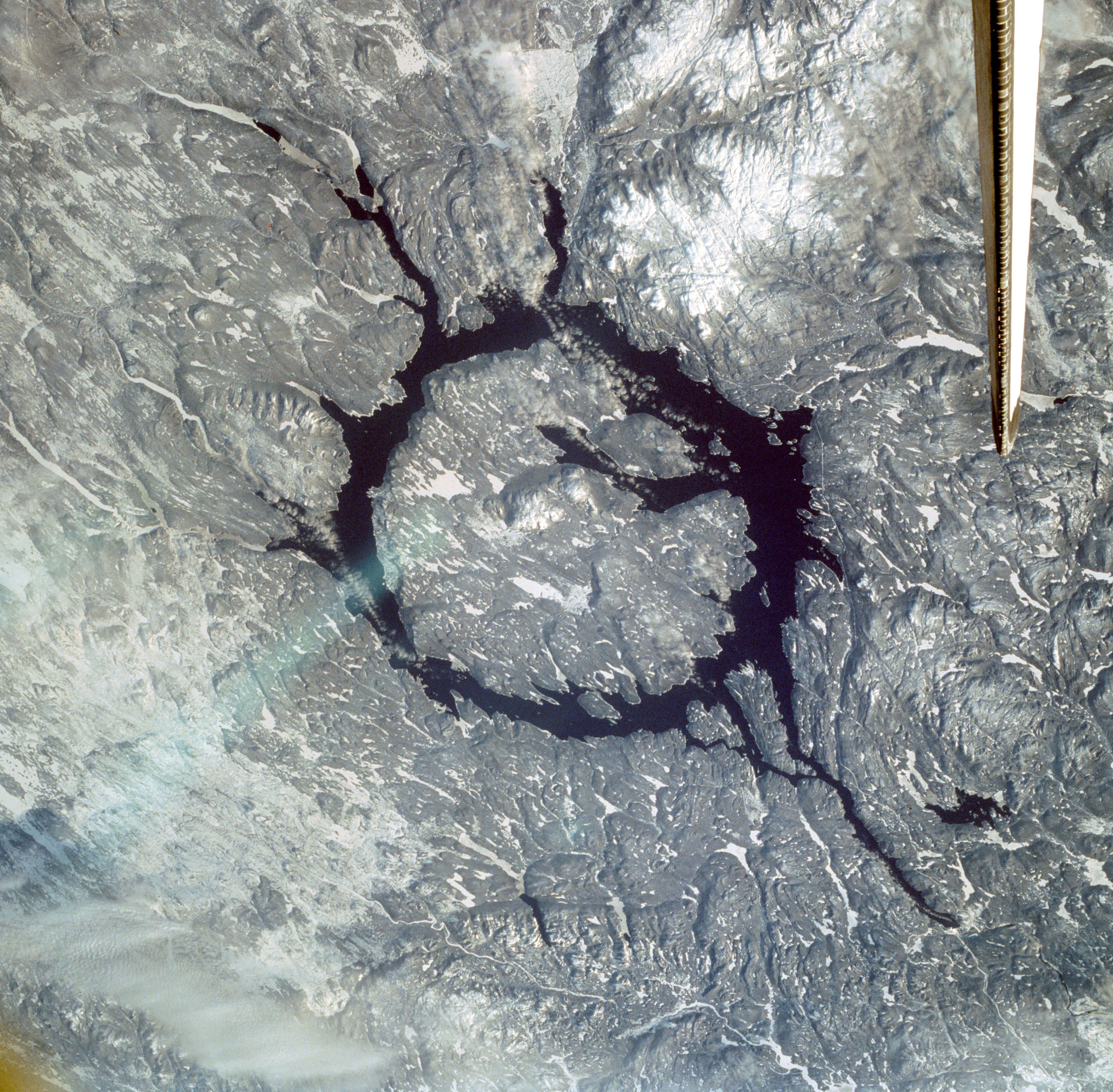 The Manicougan impact crater in Quebec, Canada, with the shuttle’s tail visible at upper right