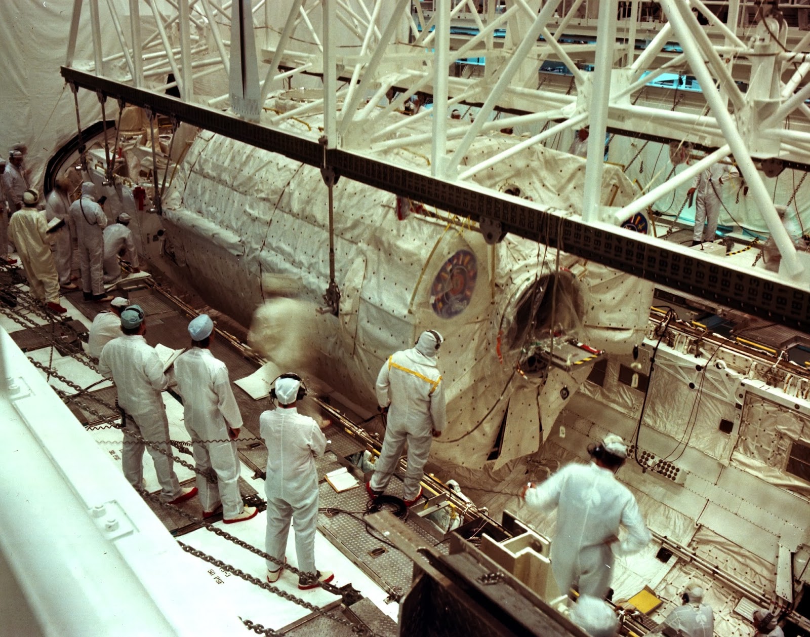 Workers place the Spacelab module and pallet into Columbia’s payload bay in KSC’s Orbiter Processing Facility
