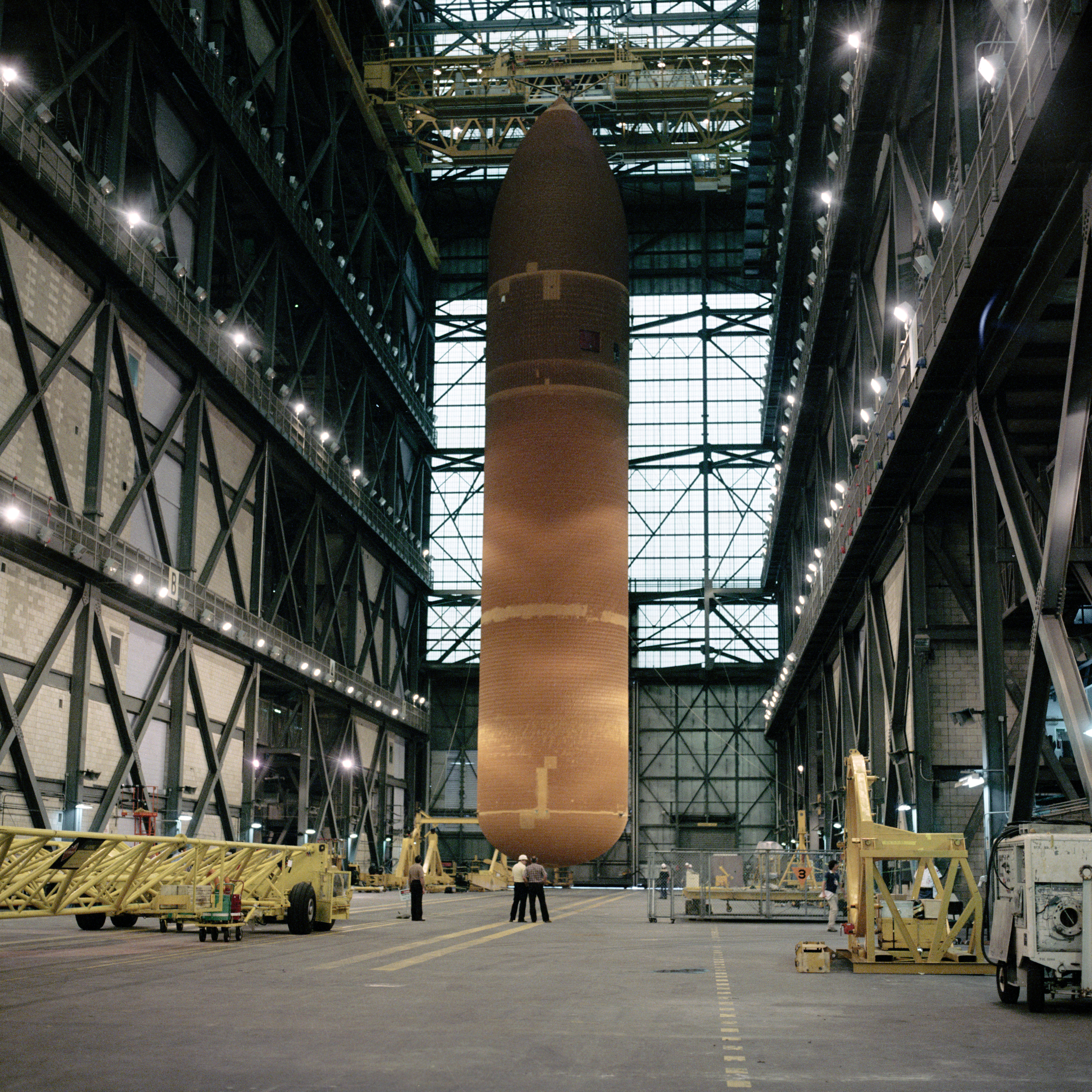 In the VAB, workers have disassembled the stack and prepare to reposition the ET with its SRBs