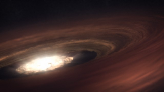 Looking in from the outer edge of a dusty, spinning disk surrounding a bright central star, which is illustrated as an indistinct bright region in the center of the disk. Rays of light emanate from the central area. A dark gap in the disk appears between the bright core and the dusty, hazy outer regions, which build up slightly as you move outward, so that the core appears sunken. The outer disk has some bands of varying thickness, in varying shades of orange.