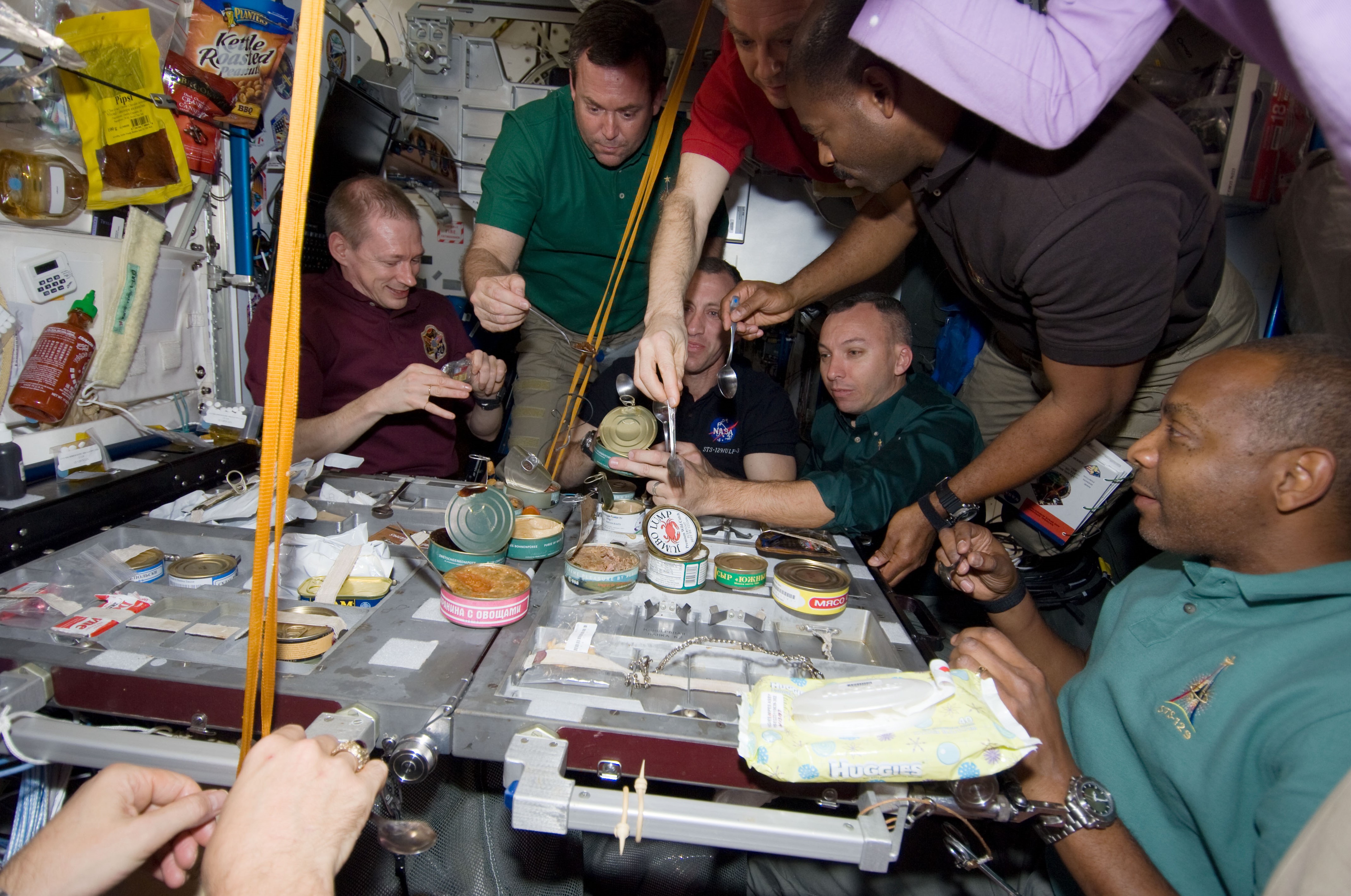 Crew members from Expedition 21 and STS-129 share an early Thanksgiving meal