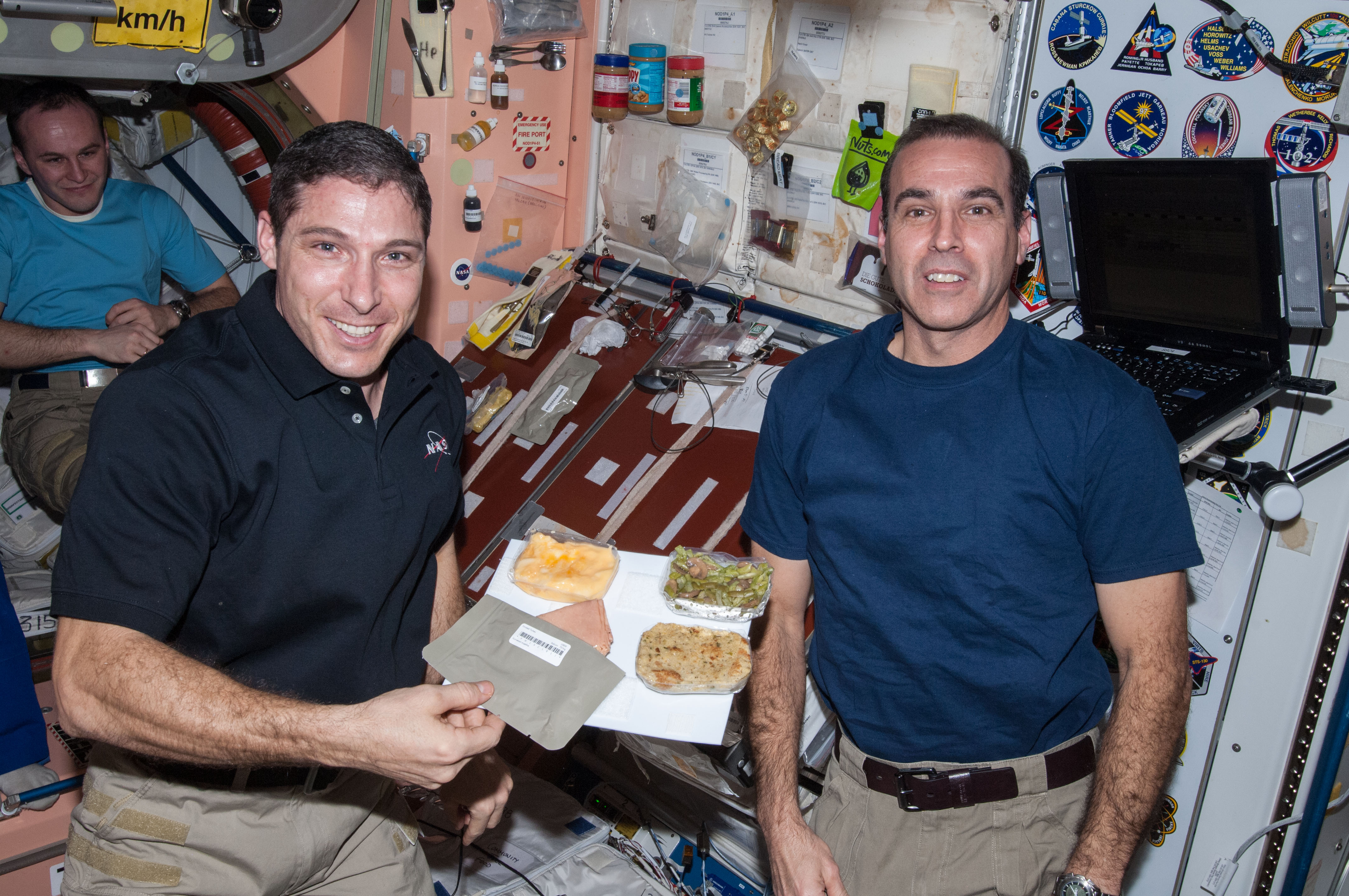 Expedition 38 NASA astronauts Michael S. Hopkins, left, and Richard A. Mastracchio showing off food items destined for the Thanksgiving Day dinner