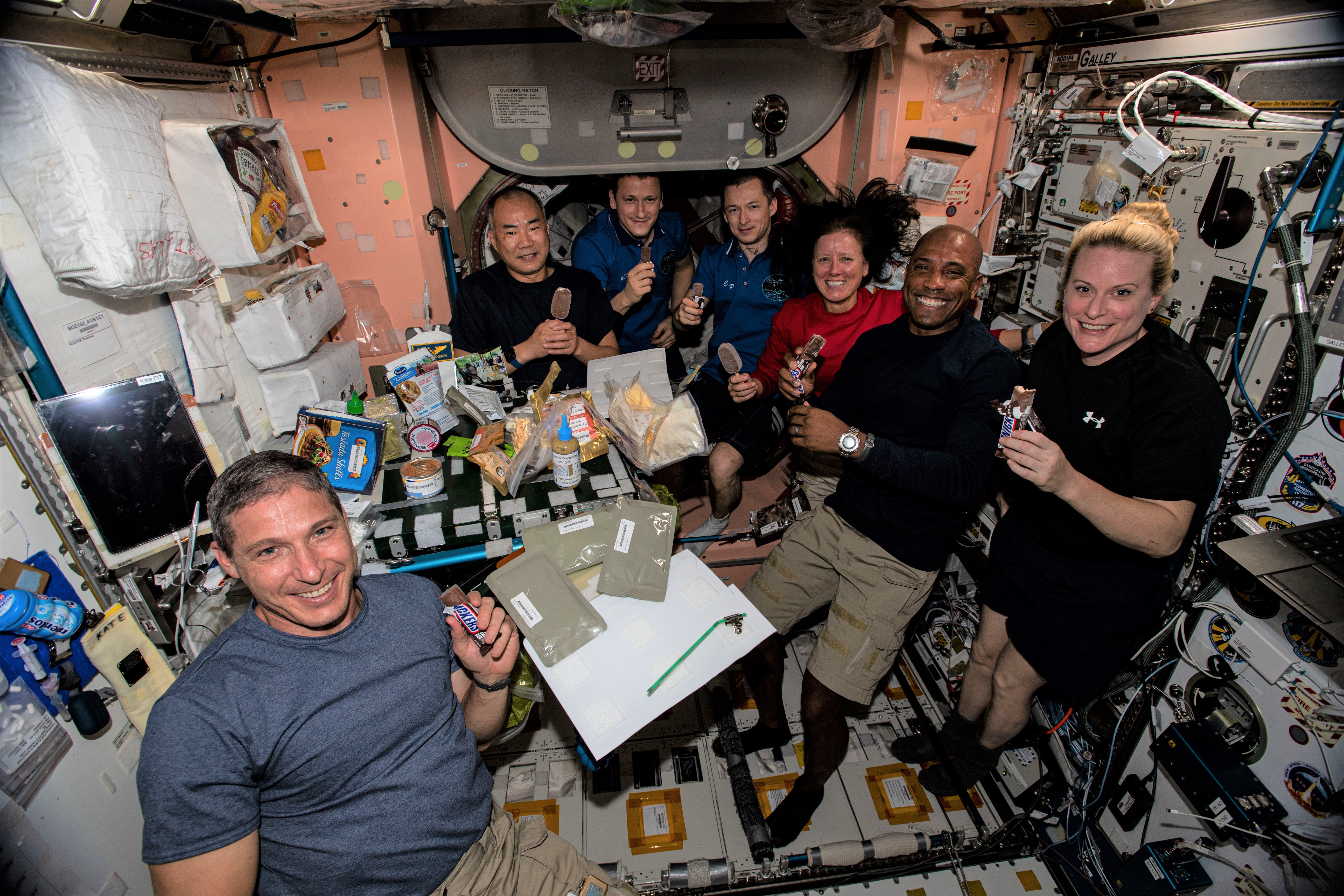 The Expedition 64 crew of NASA astronaut Michael S. Hopkins, Soichi Noguchi of the Japan Aerospace Exploration Agency, Sergei V. Kud-Sverchkov and Sergei N. Ryzhikov of Roscosmos, and NASA astronauts K. Meghan McArthur, Victor J. Glover, and Rubins enjoying the Thanksgiving meal including frozen treats for dessert