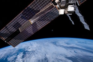 iss070e036961 (Dec. 8, 2023) -- As the International Space Station soared 260 miles above the Middle East, the blue glow of Earth is met with clouds hanging overhead. Above it, exterior station hardware and one of the orbital lab's roll-out solar arrays can be seen.