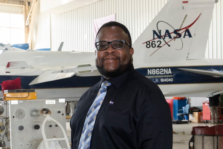 Portrait of Larry J. Cliatt II in front of an aircraft in a hangar.