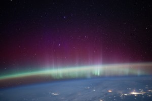 An aurora intersects Earth's airglow beneath a starry sky in this photograph from the International Space Station as it orbited 261 miles above western Kazakhstan near the Caspian Sea.