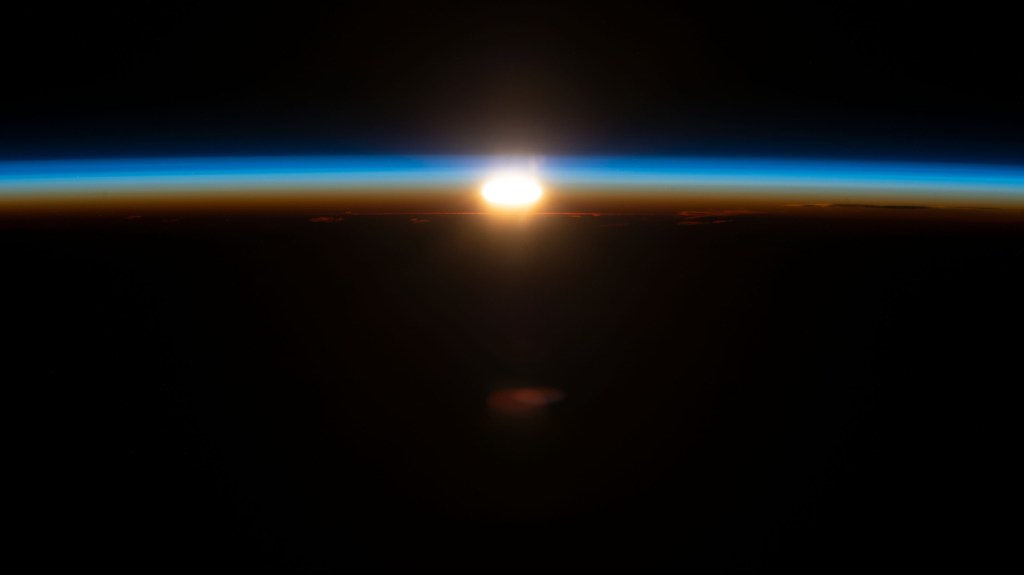 An orbital sunrise begins to illuminate Earth's atmosphere in this photograph from the International Space Station as it orbited 270 miles above the south Pacific Ocean about 2,200 miles west of New Zealand.