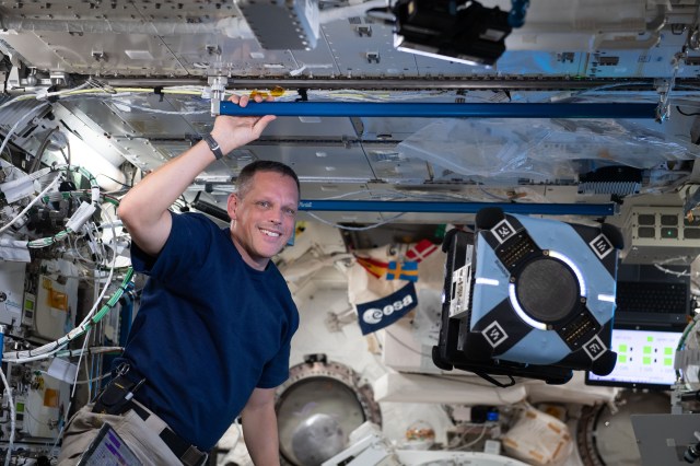 NASA astronaut and Expedition 67 Flight Engineer Bob Hines monitors an Astrobee robotic free-flyer as it tests its ability to autonomously navigate and maneuver inside the Kibo laboratory module using smartphone technology.