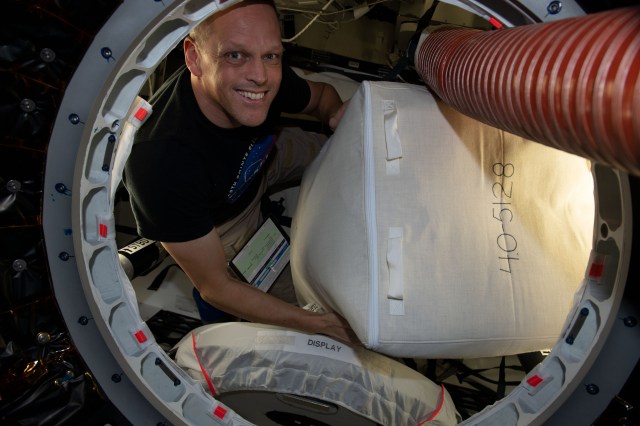NASA astronaut and Expedition 67 Flight Engineer Bob Hines is pictured packing cargo inside the SpaceX Dragon resupply ship before it undocked from the International Space Station on Aug. 19, 2022.