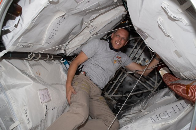 Expedition 67 Flight Engineer and NASA astronaut Bob Hines poses inside the Bigelow Expandable Activity Module (BEAM) packed with cargo and attached to the International Space Station's Tranquility module.