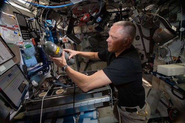 NASA astronaut and Expedition 67 Flight Engineer Bob Hines works inside the International Space Station's Harmony module and replaces a carbon dioxide bottle inside the Plant Habitat Facility that supports space agricultural research.