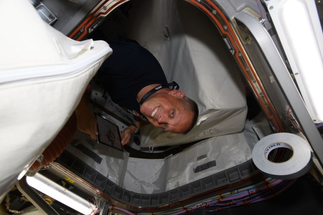 NASA astronaut and Expedition 67 Flight Engineer Bob Hines is pictured inside the vestibule between the International Space Station's Unity module and the U.S. Cygnus space freighter from Northrop Grumman.