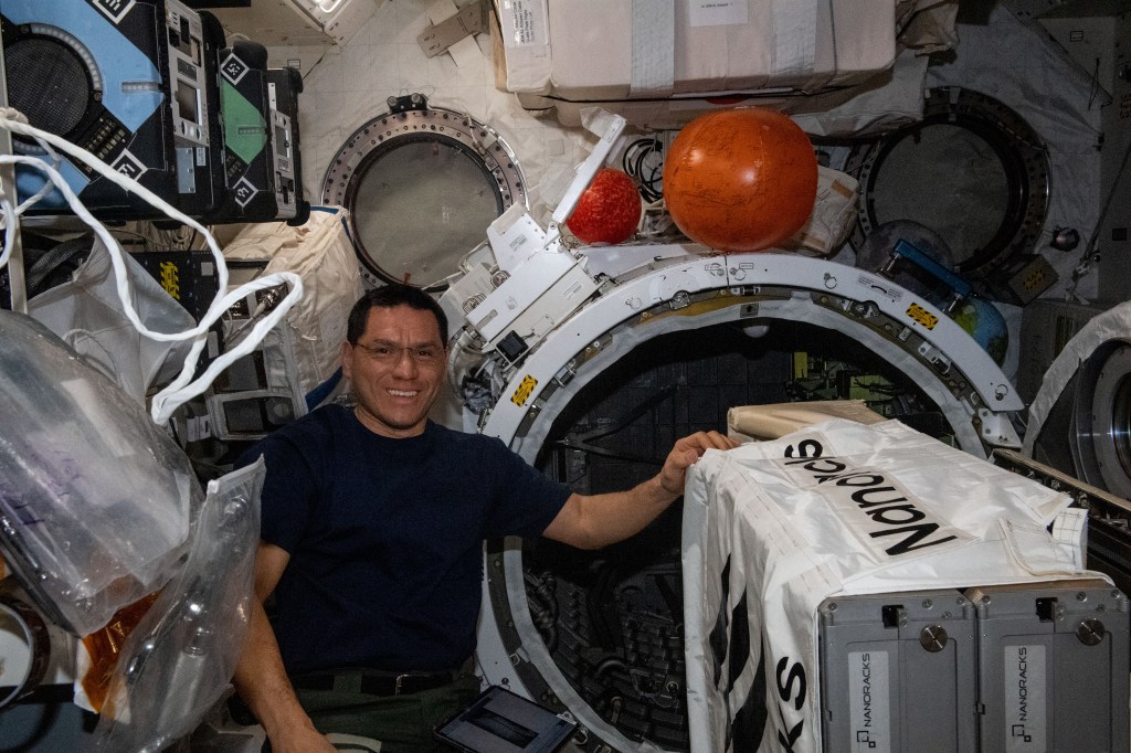 NASA astronaut and Expedition 69 Flight Engineer Frank Rubio works to install the NanoRacks CubeSat Deployer inside the Kibo laboratory module's airlock. After the airlock is depressurized, the Japanese robotic arm grapples the deployer and places it outside in the vacuum of microgravity pointing it away from the International Space Station. CubeSats from private, governmental, and academic organizations are then deployed into Earth orbit for a variety of research objectives.