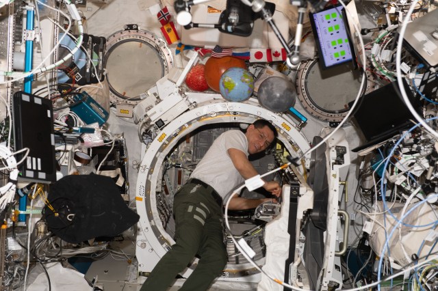 NASA astronaut and Expedition 69 Flight Engineer Frank Rubio removes science hardware from inside the Kibo laboratory module's airlock aboard the International Space Station.