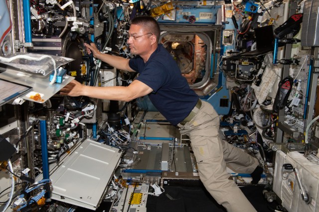 NASA astronaut and Expedition 67 Flight Engineer Kjell Lindgren checks filter, hose, and gas connections inside the International Space Station's Combustion Integrated Rack, a research device that enables safe investigations into how flames, fiuel, and soot behave in microgravity.