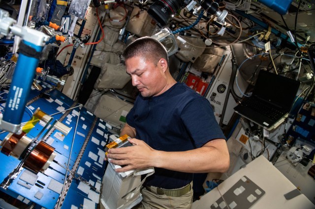 Expedition 67 Flight Engineer and NASA astronaut Kjell Lindgren checks airflow and water absorption capabilities on spacesuit components at the maintenance work area inside the International Space Station's Harmony module.