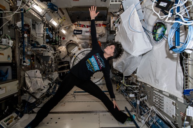 ESA (European Space Agency) astronaut and Expedition 67 Flight Engineer Samantha Cristoforetti exercises and practices yoga maneuvers while attached to hand and foot rails inside the Kibo laboratory module.