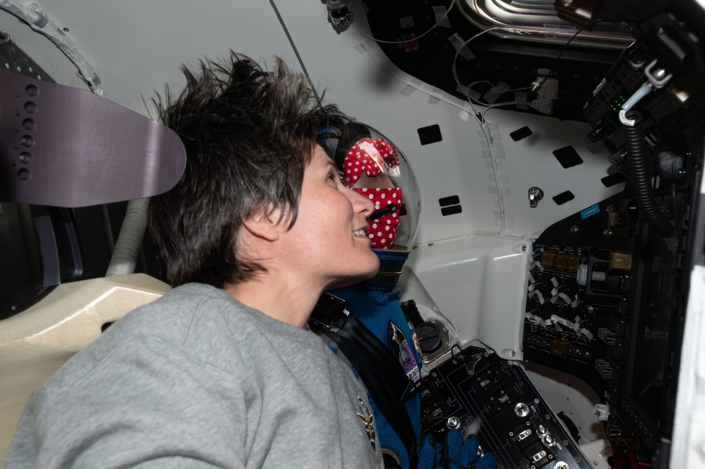 ESA (European Space Agency) astronaut Samantha Cristoforetti is seated next to "Rosie the Rocketeer" inside Boeing's CST-100 Starliner spacecraft the day after it had docked to the International Space Station's Harmony module on the company's Orbital Flight Test-2 mission.