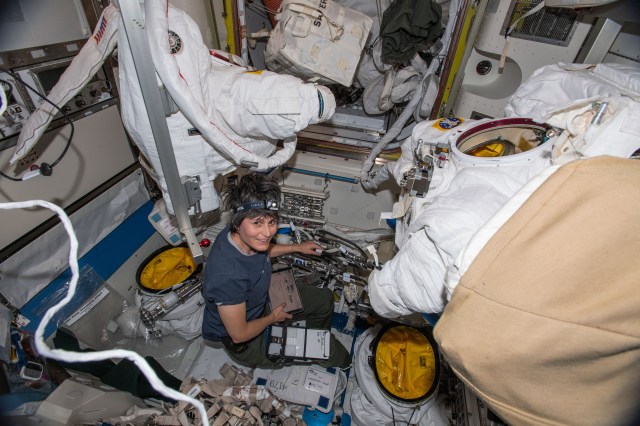 ESA (European Space Agency) astronaut and Expedition 67 Flight Engineer Samantha Cristoforetti works on U.S. spacesuits inside the International Space Station's Quest airlock.