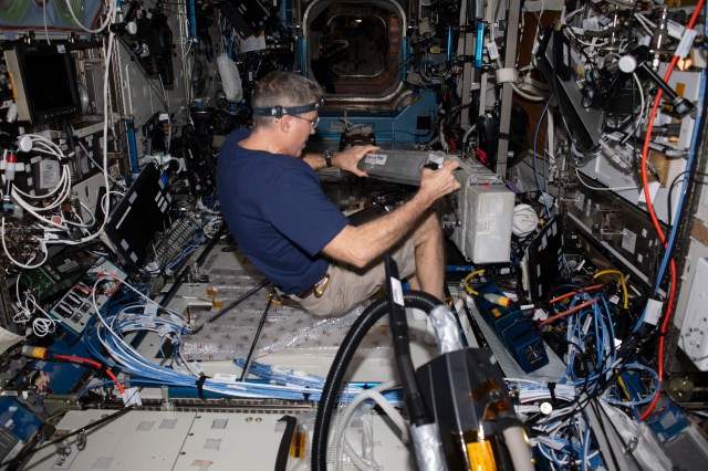 NASA astronaut and Expedition 69 Flight Engineer Stephen Bowen replaces charcoal filters in the Destiny laboratory module as part of life support maintenance aboard the International Space Station.