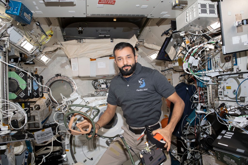 UAE (United Arab Emirates) astronaut and Expedition 69 Flight Engineer Sultan Alneyadi is pictured holding portable breathing gear inside the International Space Station's Kibo laboratory module.