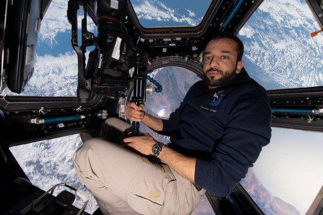 UAE (United Arab Emirates) astronaut and Expedition 69 Flight Engineer Sultan Alneyadi is pictured with camera gear inside the seven window cupola as the International Space Station orbited 263 miles above Cape Town, South Africa.