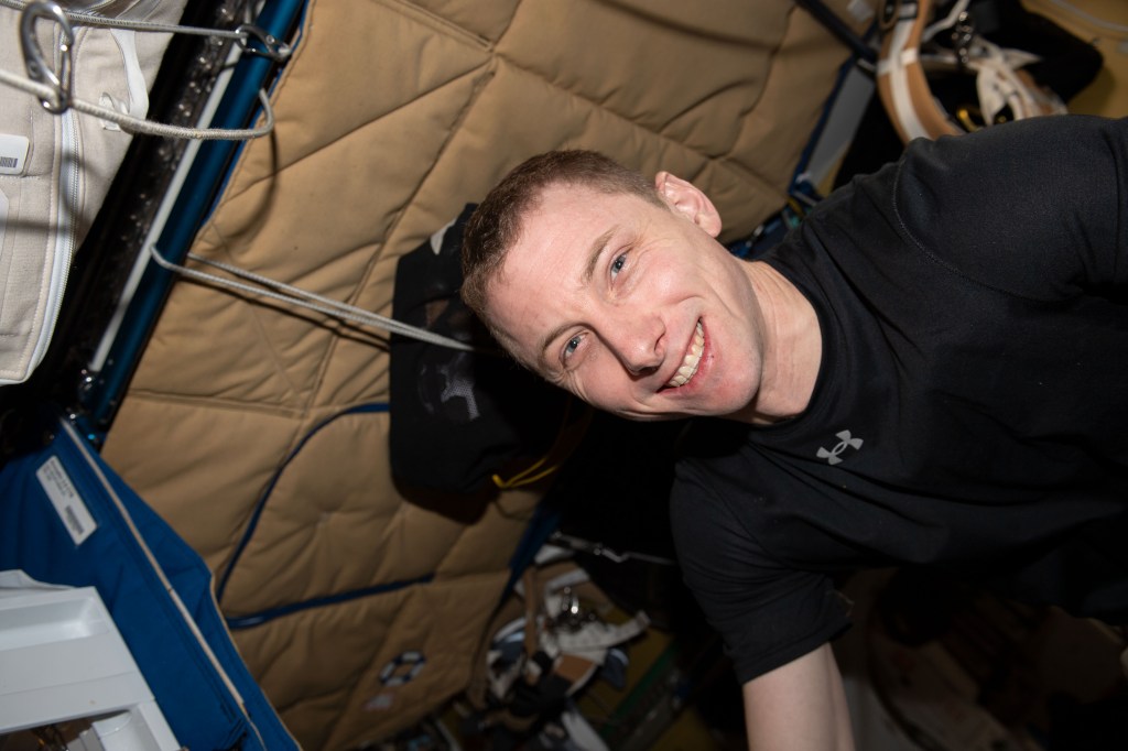 NASA astronaut and Expedition 69 Flight Engineer Woody Hoburg poses for a portrait during an exercise session inside the International Space Station's Tranquility module.