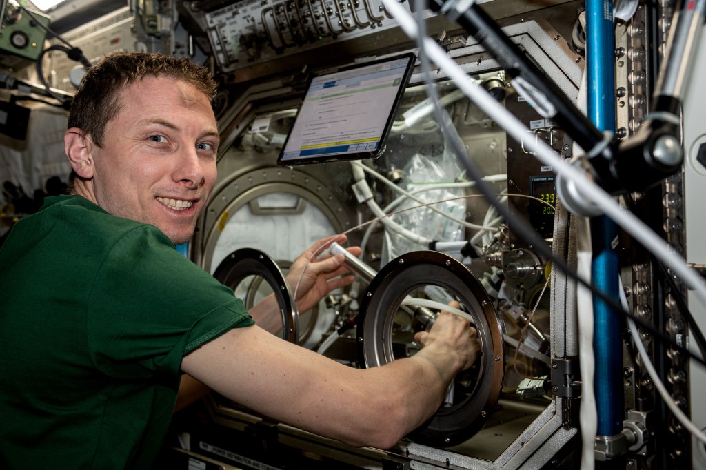 NASA astronaut Woody Hoburg swaps samples for a space manufacturing study inside the Microgravity Science Glovebox (MSG) in the International Space Station's U.S. Destiny Laboratory Module. MSG allows crews to investigate physical science and biological research in a safe, contained environment in microgravity.