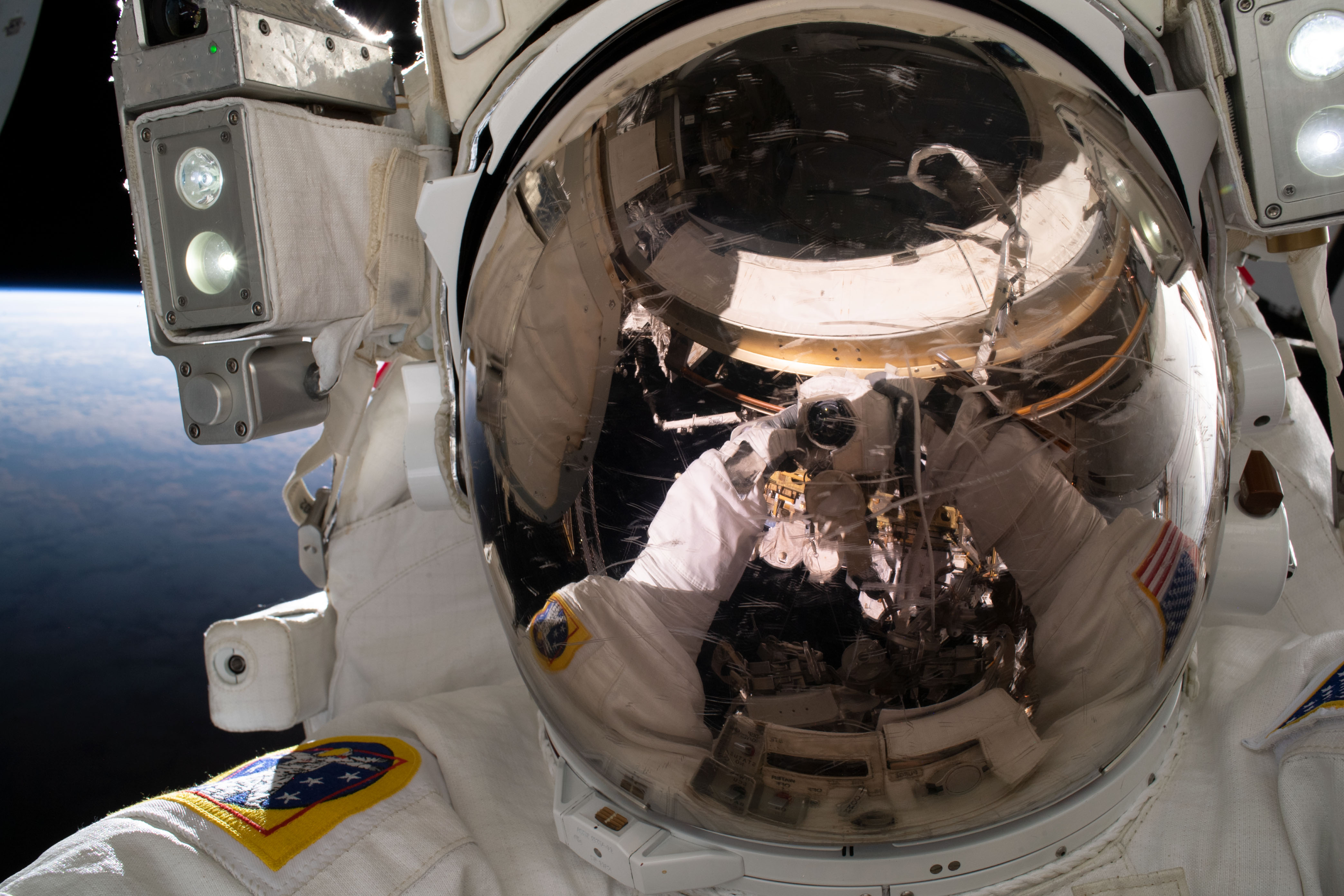 NASA astronaut and Expedition 68 Flight Engineer Woody Hoburg points the camera toward himself and takes an out-of-this-world "space-selfie" during a five-hour and 35-minute spacewalk to install a roll-out solar array on the International Space Station's truss structure.