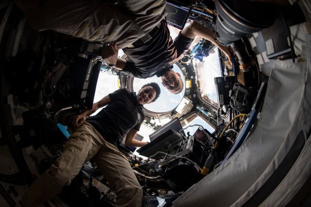 NASA astronauts Bob Hines and Jessica Watkins are pictured inside the cupola, the International Space Station's "window to the world," after monitoring the successful rendezvous and docking of the SpaceX Dragon space freighter on its 25th Commercial Resupply Services mission.