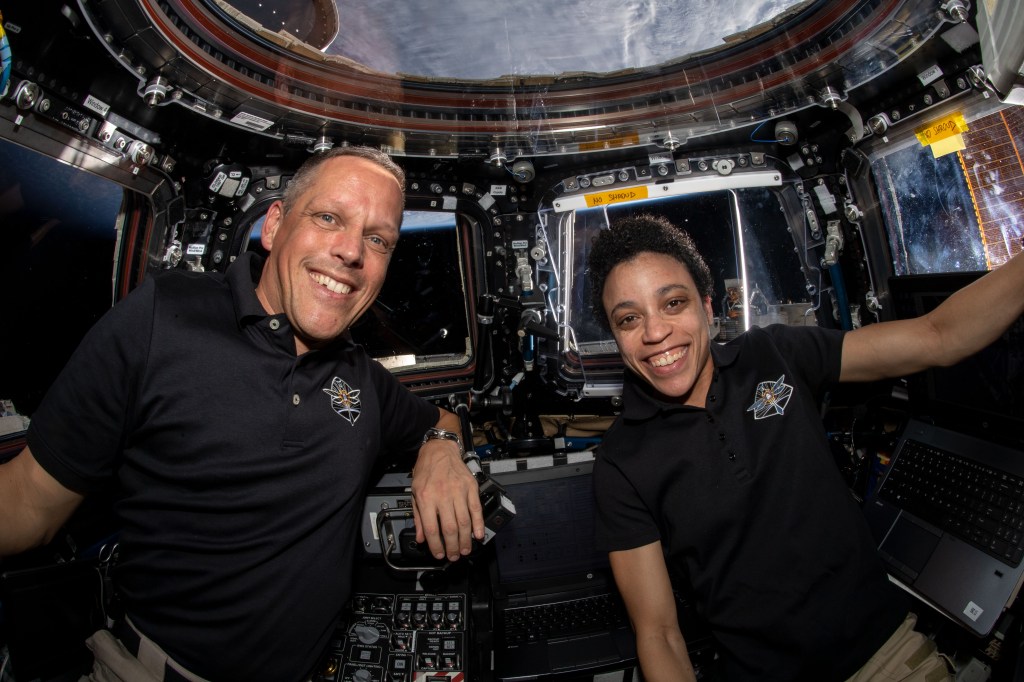 NASA astronauts Bob Hines and Jessica Watkins are pictured inside the cupola, the International Space Station's "window to the world," after monitoring the successful rendezvous and docking of the SpaceX Dragon space freighter on its 25th Commercial Resupply Services mission.