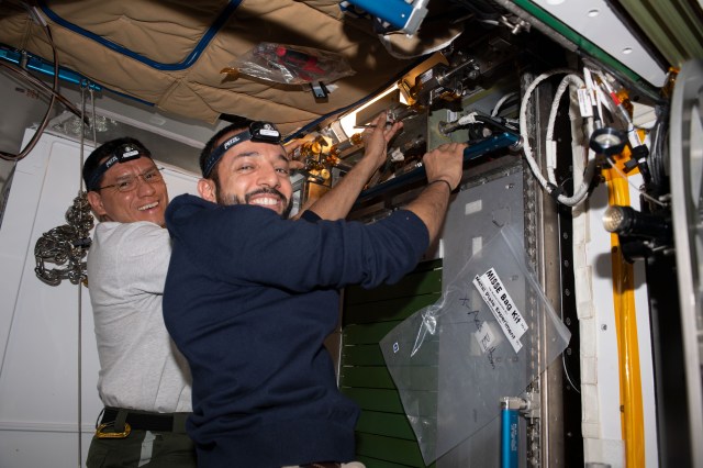 From left, Expedition 69 Flight Engineers Frank Rubio of NASA and Sultan Alneyadi of UAE (United Arab Emirates) return the station’s Treadmill 2 to its normal configuration inside the International Space Station's Tranquility module after an inspection and cleaning of its electronic components.