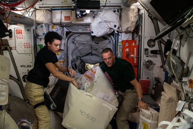 Expedition 67 Flight Engineers Jessica Watkins and Bob Hines, both from NASA, unload cargo and time-critical science experiments a couple of hours after the SpaceX Dragon resupply ship docked to the Harmony module's forward port on the International Space Station.